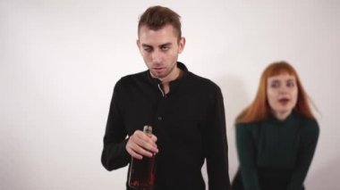 Agresif bir şişe ve üzgün genç kadın bağırıyor ve ağlayarak uzun kızıl saçlı içme alkol bouttle adamla içti.