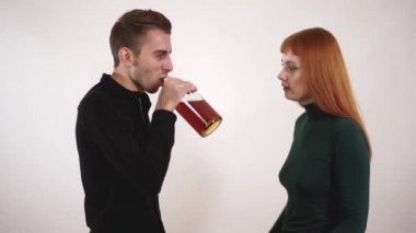 Depresif alkolik kocası için eğilerek ve ondan bir şişe alkol almaya çalışırken çaresiz duygu duygusal sevecen sevgi dolu eşi.