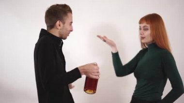 Depresif alkolik kocası için eğilerek ve ondan bir şişe alkol almaya çalışırken çaresiz duygu duygusal sevecen sevgi dolu eşi.