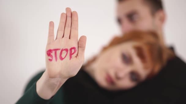 Silhouette eines Paares auf weißem Hintergrund, Mann kuschelt Frau und streicht ihr über den Kopf, Frau zeigt schriftliches Zeichen an ihrer Hand "Stopp" Gewalt — Stockvideo