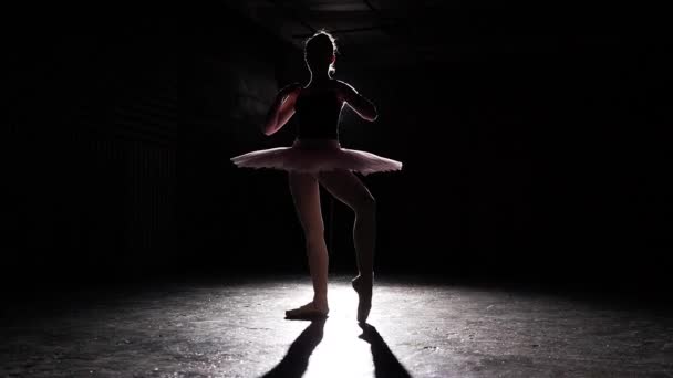 芭蕾的剪影查出在黑色背景。年轻苗条的芭蕾舞演员练习芭蕾。芭蕾舞演员穿着短裙和尖鞋。女人表演经典的芭蕾帕兹。慢动作. — 图库视频影像