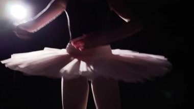 Profesyonel balerin pointe bale ayakkabılarını Studio siyah arka plan üzerine spot içinde dans. Balet tutu ve pointe ayakkabıları klasik bale pas gösterir. Ağır çekim.