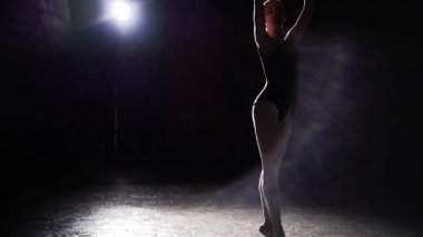 Profesyonel esnek balerin pointe bale ayakkabılarını Studio siyah arka plan üzerine spot içinde dans. Balet tutu ve pointe ayakkabıları klasik bale pas gösterir. Ağır çekim.