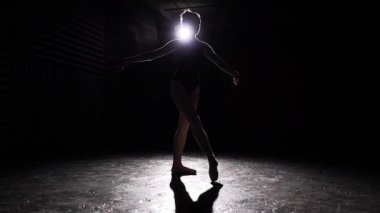 Pointe bale ayakkabılarını Studio siyah arka plan üzerine spot içinde dans genç profesyonel zarif esnek balerin. Ağır çekim.