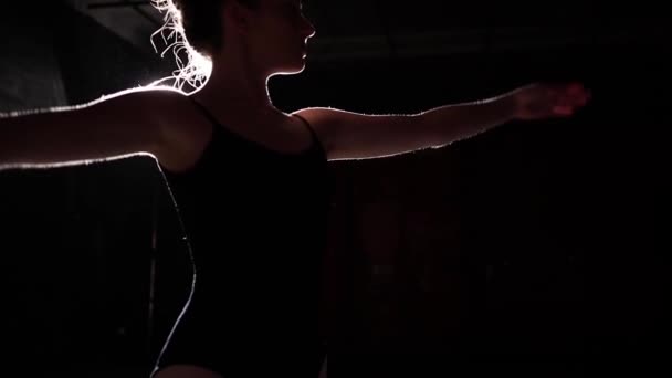 Χαριτωμένη όμορφη μπαλαρίνα στέκεται στο προσκήνιο σε μαύρο φόντο σε στούντιο. Αργή κίνηση. — Αρχείο Βίντεο