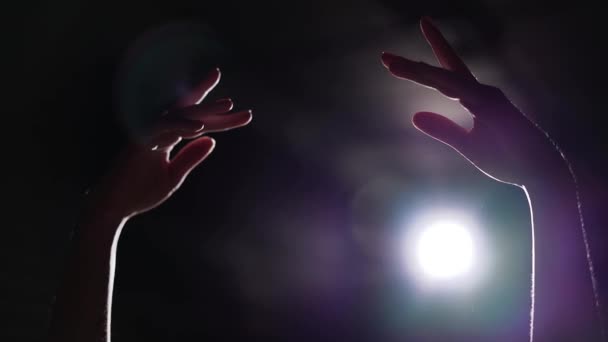 Κοντινό πλάνο γυναικεία χέρια υψώνεται στα φώτα της δημοσιότητας σε μαύρο φόντο — Αρχείο Βίντεο