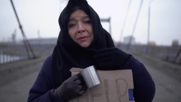 Retrato de adultos sin hogar triste estancia en el puente en el frío viento gris pidiendo limosna y caridad — Vídeos de Stock