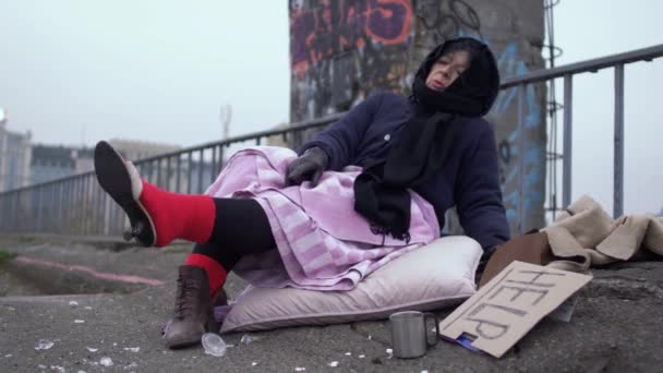 无家可归的女人欣赏穿在厚厚的红色袜子上的鞋子, 并欣赏地看着夹克. — 图库视频影像