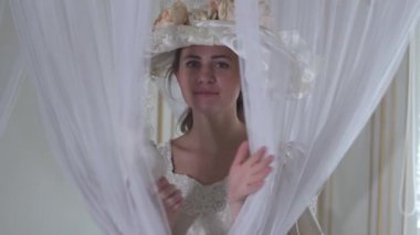 Portre eğlenceli güleryüzlü oynak genç kadın beyaz vintage top elbise ve beyaz şapka şeffaf tül açılış yüz gösterilen.