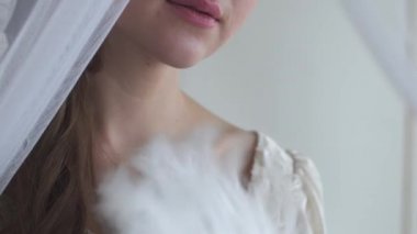 Kadın el tutkunları yüzü beyaz tüy fan beyaz arka plan yarım yüz gerçek insanlar serisi ile kapatın. Perde arkasına saklanan