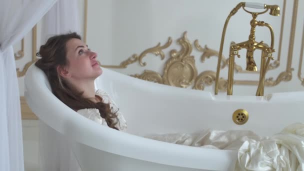 Junge lächelnde Frau im Vintage-Badezimmer in der Badewanne liegend, in Ballkleid aus nächster Nähe — Stockvideo