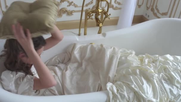 Étrange fille en robe de bal met oreiller sous sa tête couché dans le bain et dort de près — Video