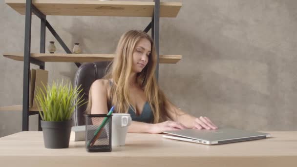 귀여운 관능적인 smilling 여자 란제리 선반 근처 검은 가죽의 자에 내려 테이블 앉아 오는 그녀의 노트북 열고 입력을 시작 합니다. 아름 다운 외로운 아가씨의 레저. — 비디오