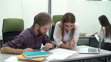 Yeni planlama yaratıcı iş arkadaşları masada oturan rahat modern ofis çalışma proje. İki kişi fiş boşaltmaya karışan iş., kadın gülümsüyor, eşi ciddi ve yoğun.