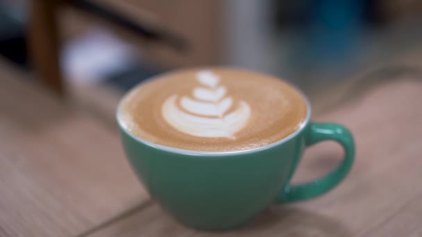 Beatifully bereid hete latte met blad ontwerp in een turquoise cup met perfect crema en schuim. Close-up — Stockvideo