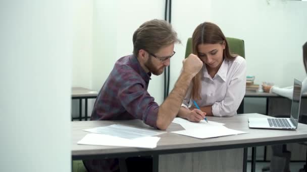 Hombre y mujer trabajan en una cómoda oficina moderna con computadora portátil. Proceso de trabajo — Vídeo de stock