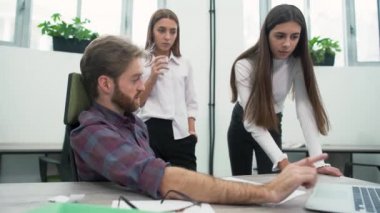 Odaklı üç ekip üyeleri proje tartışmak ve içine belgili tanımlık bilgisayar, en iyi çözüm bulmaya bak