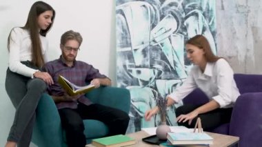 Ofis çalışanları oturan rahat koltuklar ve çalışma kağıtları. Modern ofis yaratıcı iş takım toplantısı. İş planları rahat bir ortamda tartışılması.
