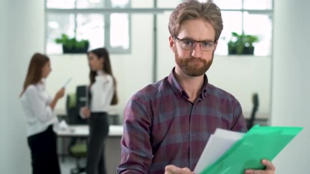 Manager controles informatie zoeken in documenten die permanent in de hal close-up met baard — Stockvideo