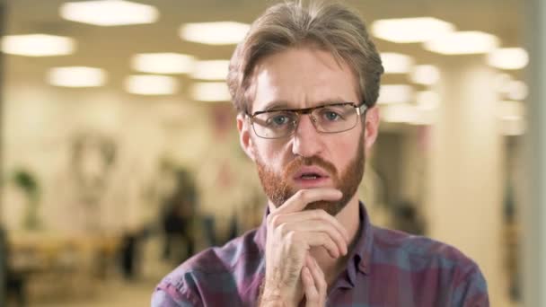 Retrato del hombre barbudo mirando en cámara tocando nerviosamente su cara de cerca — Vídeos de Stock