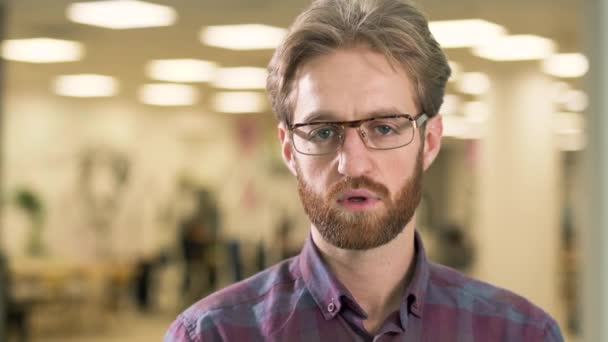 Modern hub arka plan üzerinde zor bir sorunu çözmek nasıl bir fikir bulmaya çalışan genç çekici ciddi adam portresi — Stok video