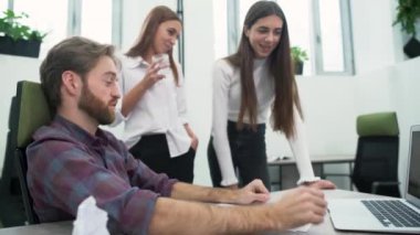 Sakallı bir adam ve iki genç kız işyerinde ofiste iş planı görüşüyorlar. Üst düzey yönetici fikirlerini arkadaşları dizüstü bilgisayar ekranında gösterir.