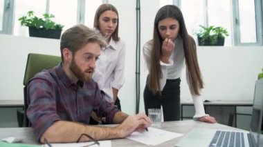 Mutlu ofis çalışanları büyüme oranları ne zaman bir dizüstü bilgisayar ekranına bakarak sevinirler. İş arkadaşlarınızla birlikte eğleniyor. Kadınlar, gülümseyen adam dans ediyor sandalyede oturan