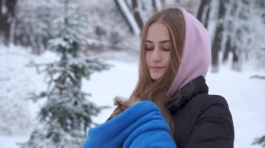 Portre sevimli genç kız a yorkshire korkunç tutarak karla kaplı bir kış parkta ellerinde mavi bir havlu sarılı. Bir genç ve açık havada yürüyüşe a evde beslenen hayvan. Ağır çekim.