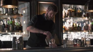 Çekici barmen mixologist buz bir kokteyl güzel modern barda yapım büyük küp ekleme. Ağır çekim