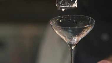 Ice cube bir kokteyl cam closeup düşüyor. Ağır çekim.