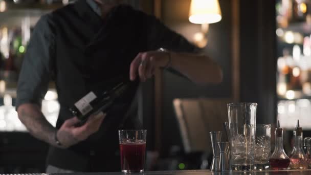 Een professionele barman opent een fles champagne of mousserende wijn terwijl staande aan de bar tegen in de kroeg. Slow motion. — Stockvideo