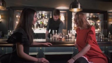 Sohbet ve bar kokteyller yapma gülümseyen barmen arka plan üzerinde gülüyorsun genç kızlar
