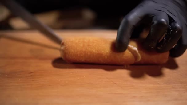 Fogão de chef em luvas perfeitamente corta em dois pedaços de bolo oleoso crocante frito com recheio de carne. Fechar — Vídeo de Stock