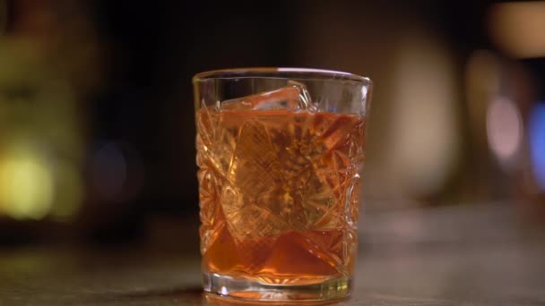 Álcool disparado com um pedaço de gelo na mesa de perto . — Vídeo de Stock