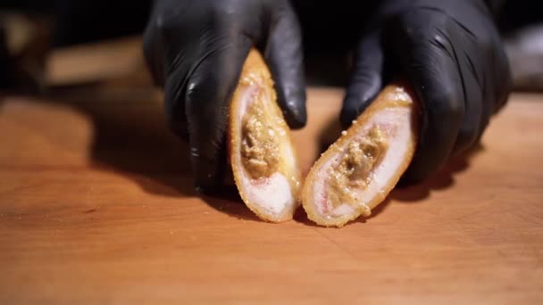 Mani in guanti di gomma nera schiacciare il patty succosa nella pasta da vicino — Video Stock