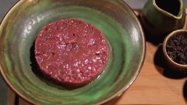 Råa tartar och ingredienser liggande i lertavlor på köksbordet. Närbild. Kulinariska och äta koncept. — Stockvideo