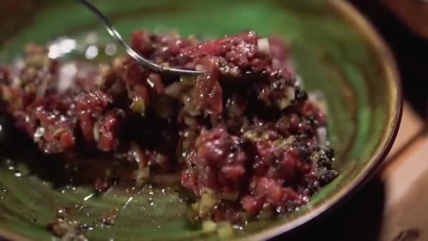 Close-up of the mixing of the tartare lying in a clay plate with a fork. Slow motion. — Stock Video