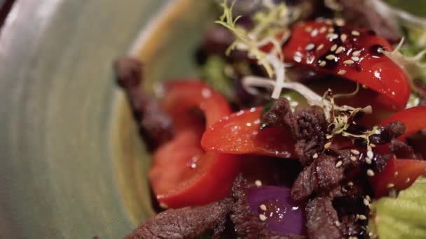 Nahaufnahme von Salat Zutaten sind auf dem Teller. gesunde Kost mit Sesam an der Spitze — Stockvideo