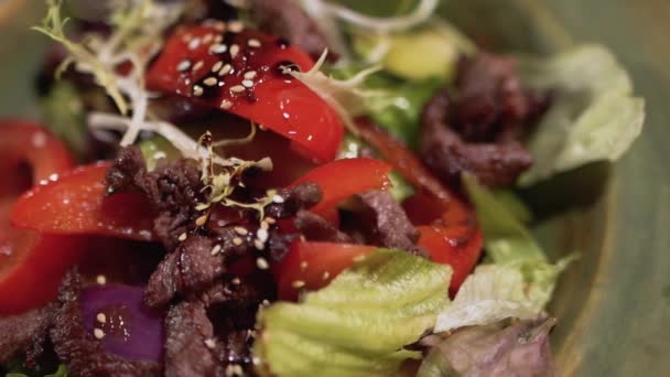 Les ingrédients de la salade sont dans l'assiette de près. Aliments sains avec du sésame sur le dessus — Video