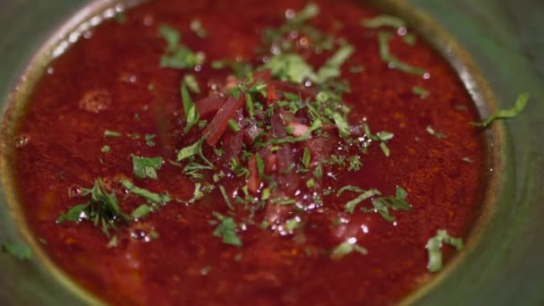 Gehakte stukjes UI veren en peterselie vallen op een plaat met smakelijke borsch. Close-up. — Stockvideo