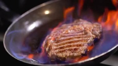 Bir kalbur güzel parlayan ateş üzerinde kızartma Barbekü. Lezzetli sığır eti biftek, sıcak Barbekü ızgara. Ağır çekim.