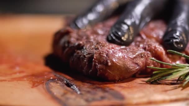 Hand in black gloves cutting meat steak with knife close up. — Stock Video