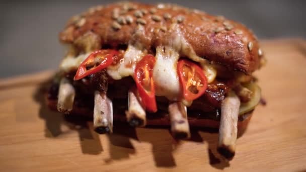 Lekker broodje met ribben liggen op de snijplank close-up. Koken voedsel met speciale recept in restaurant. Camera beweegt van links naar rechts — Stockvideo