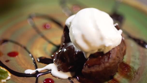 Klämde brun kaka liggande på plattan närbild. Sura och choklad rinner ner — Stockvideo