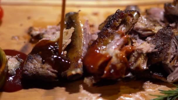 Tasty juicy ribs of beef are poured by sauce close up. Fresh meat lying on cutting board — Stock Video