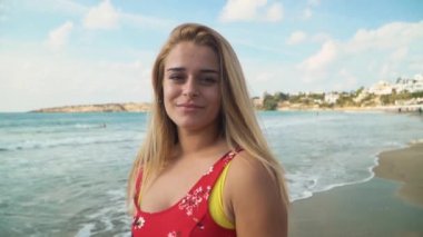 Bir kırmızı sarı saçlı güzel mükemmel güleryüzlü kız portresi elbise ayakta deniz ya da okyanus tarafından.