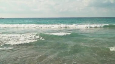 Güzel deniz manzarası. Dalgalar kıyıya rulo. Okyanus, iyi bir hava. Binalar çok kayalık tepe üzerinde vardır. Kamera sağa taşır