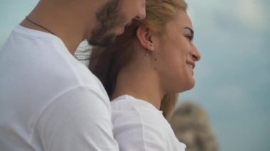 Genç adam güzel bir sarışın kadının arkasından sarılmak ve onlar mutlu konuşmak