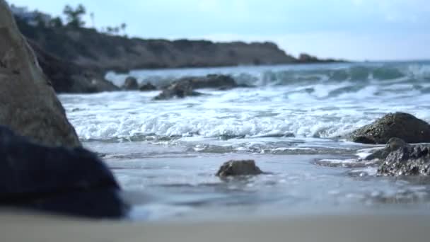 Schiuma enorme che crea da acqua cristallina blu sulla costa del Mediterraneo sullo sfondo del paesaggio roccioso. Da vicino. — Video Stock