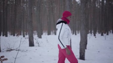 Afro-Amerikan kız kış ormanda yürüyüş. Güzel kız beyaz sıcak ceketli yalnız vakit. Açık Rekreasyon kavramı. Yan çekim